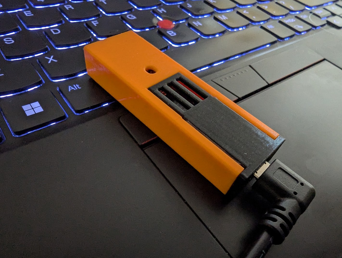 3d printed case for a microcontroller on top of a thinkpad keyboard